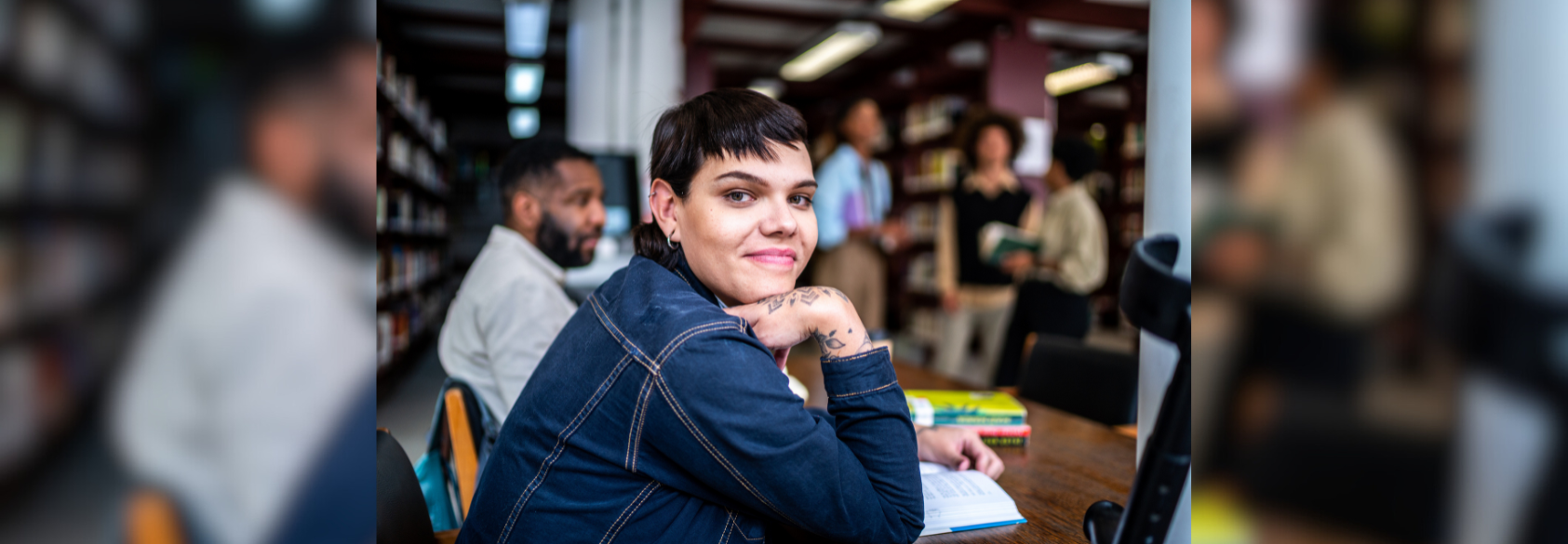 Portrait of a young transgender woman in a library stock photo