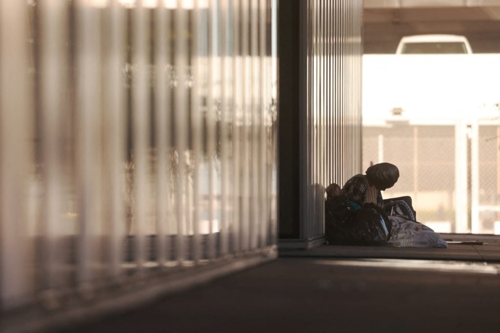 A person sleeps at Billie Jean King Library, as the city clears homeless encampments following an executive order of California Governor Gavin Newsom, in Long Beach, California, U.S. August 19, 2024. REUTERS/David Swanson